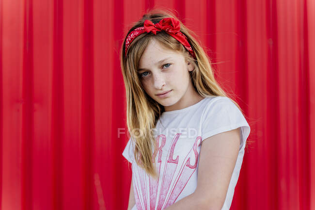Portrait de fille avec bande de cheveux devant le mur rouge — Photo de stock