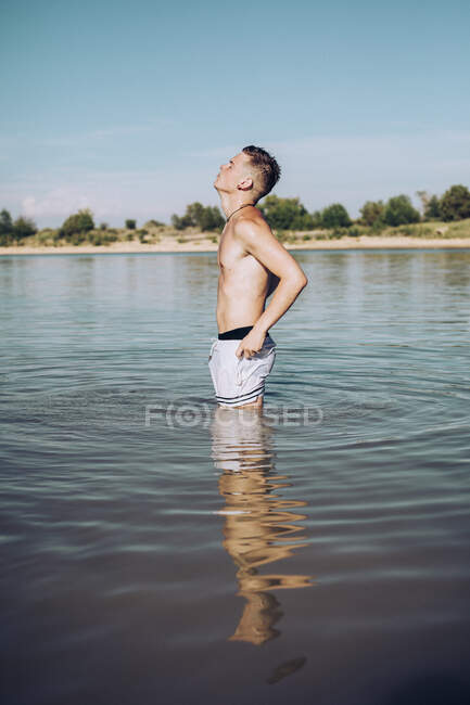 Giovane in piedi in un lago — Foto stock