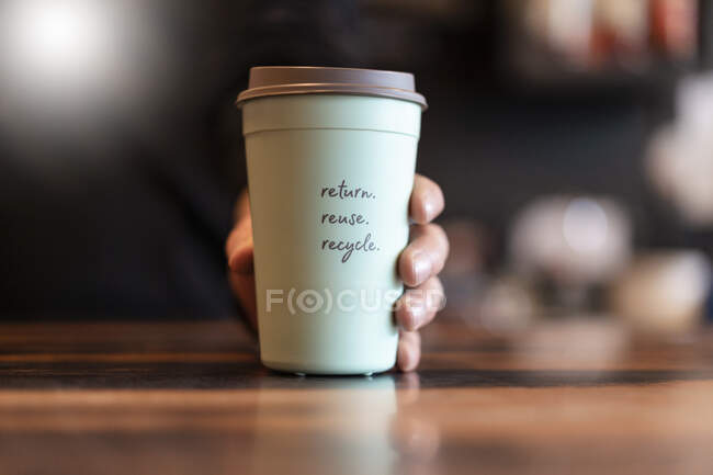 Taza de depósito de mano para café para llevar, primer plano - foto de stock
