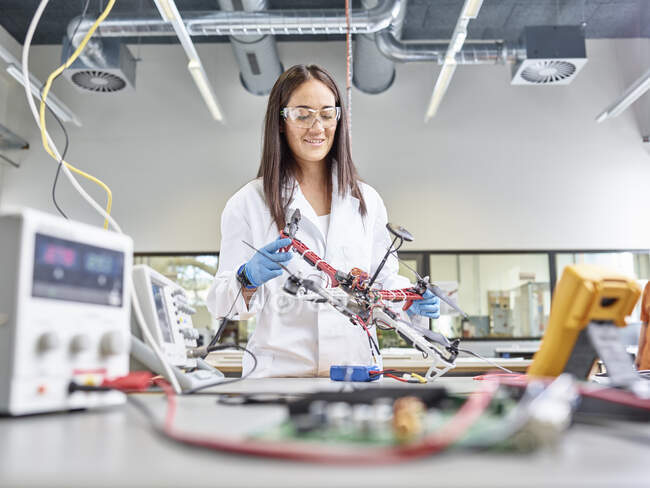 Technicienne travaillant dans un laboratoire de recherche, développant un drone — Photo de stock