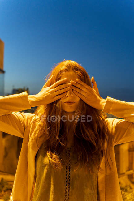 Молода жінка з руками на очах у синю годину. — стокове фото