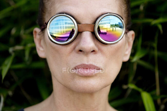 Mujer madura con gafas de soldador en frente de un edificio de oficinas - foto de stock