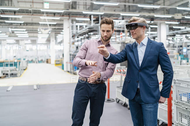 Deux hommes d'affaires avec lunettes AR dans une usine moderne — Photo de stock