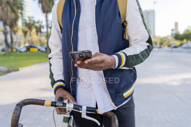 Primo piano di un uomo d'affari occasionale con la bicicletta utilizzando il cellulare in città, Barcellona, Spagna — Foto stock