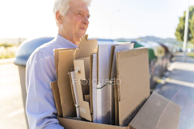 Homem sênior reciclagem de papelão transportando caixa de papelão — Fotografia de Stock