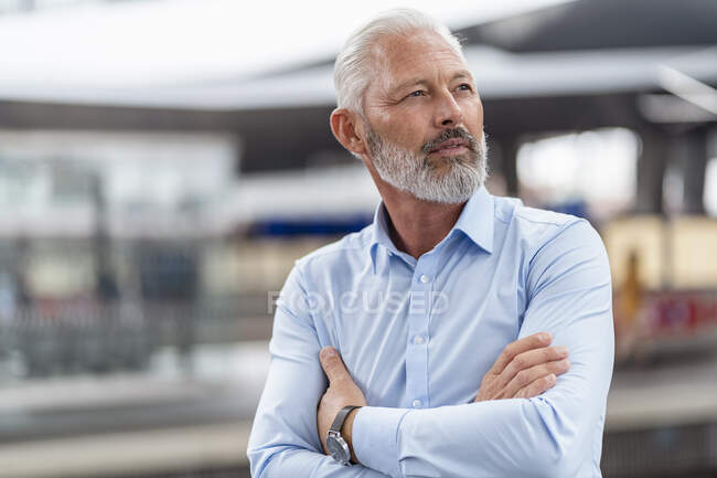Зрелый бизнесмен на платформе станции осматривается — стоковое фото