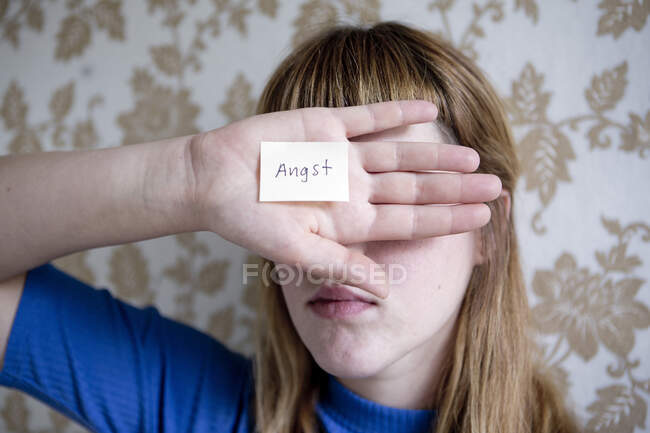 Estudiante mostrando su mano, una nota con la palabra miedo en su mano - foto de stock