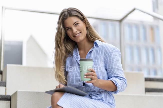 Retrato de jovem empresária usando tablet, com café para ir xícara — Fotografia de Stock