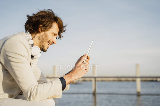 Сміється бізнесмен, користуючись цифровим планшетом на вулиці. — стокове фото