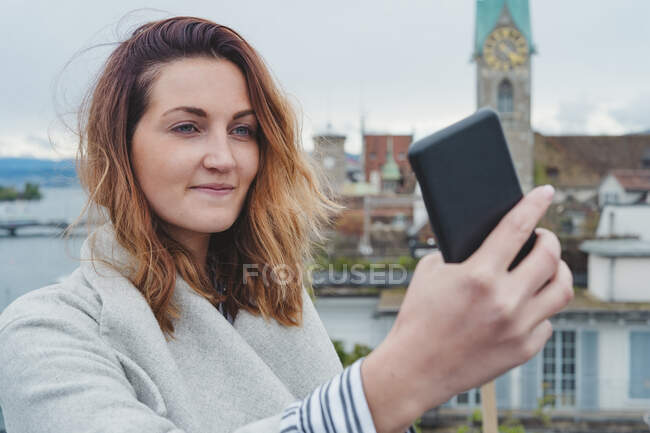 Young woman taking smartphone picture in the city, Zurich, Switzerland — Stock Photo