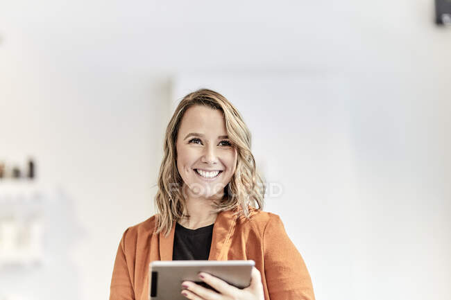 Portrait of smiling young businesswoman with mini tablet — Stock Photo