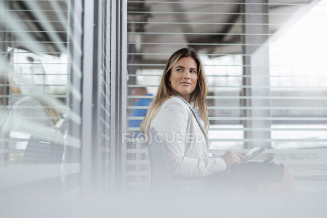 Jeune femme d'affaires utilisant une tablette dans une salle d'attente — Photo de stock