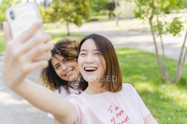 Two happy women taking a selfie in park — Stock Photo