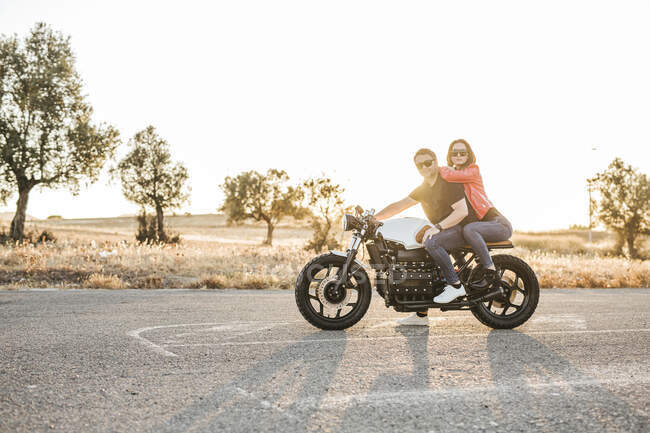 Retrato de pareja sentada en moto al atardecer — Relación, adultos - Stock  Photo | #461500532