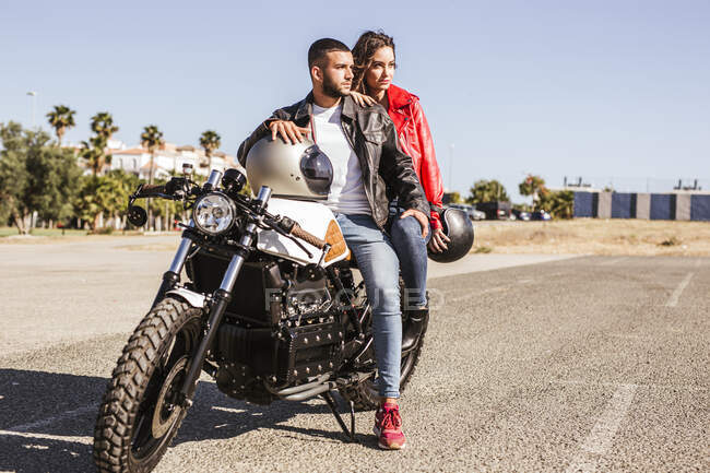 Couple sitting on motorbike looking at distance — Stock Photo