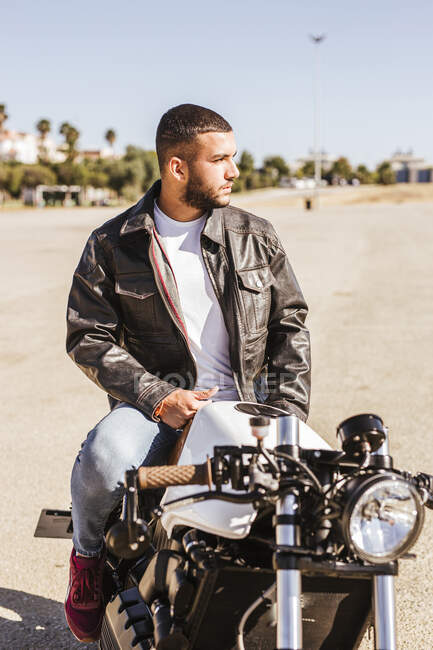 Портрет бородатого юнака, який сидить на своєму мотоциклі. — стокове фото