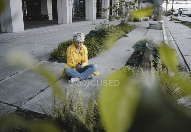 Femme mature utilisant un smartphone en plein air — Photo de stock