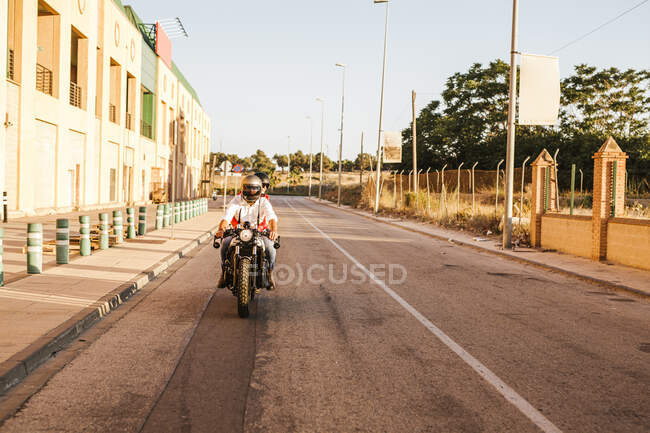 Пара їде на мотоциклі у вечірній сутінках. — стокове фото