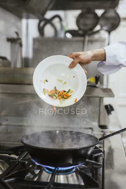 Junior chef friggere verdure — Foto stock
