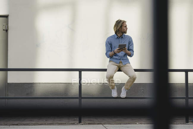 Junger Mann mit Tablet in der Stadt schaut sich um — Stockfoto