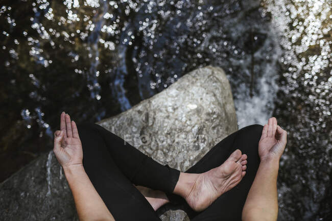 Close-up of woman practicing yoga at a brook — Stock Photo