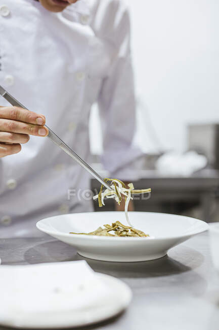 Junior chef prepairing a meal on plate — Stock Photo