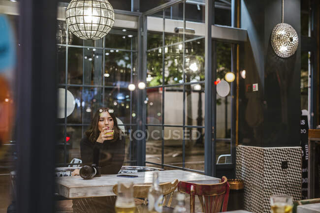 Молода жінка з камерою в барі вночі — стокове фото