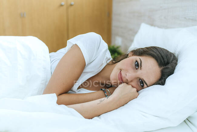 Портрет молодої жінки, що лежить у ліжку. — стокове фото
