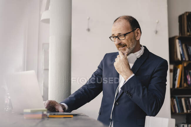 Mature businessman using laptop in a cafe — Stock Photo