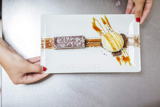 Junior chef with prepaired dessert on plate, from above — Stock Photo