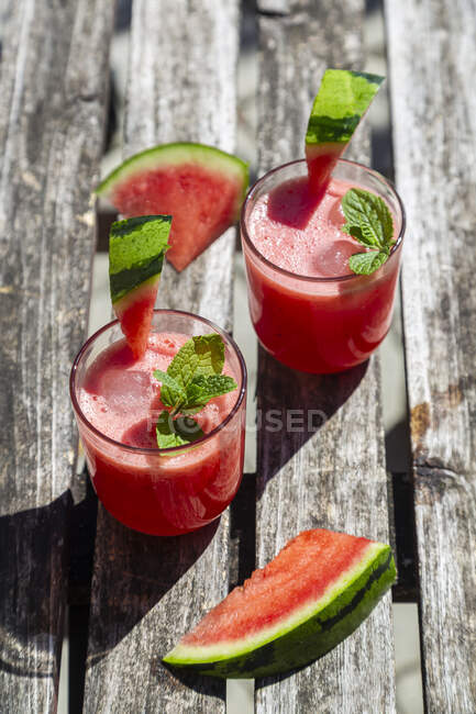 Watermelon juice with fresh mint and ice cubes on wooden background — Stock Photo