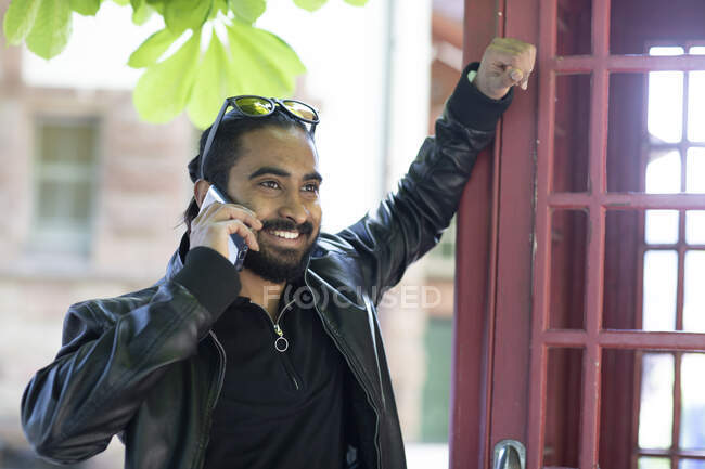 Portrait of smiling young man on the phone outdoors — Stock Photo