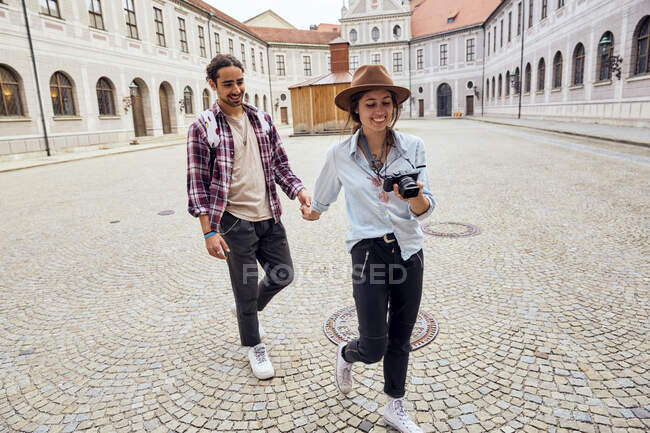 Giovane coppia di turisti a piedi nel cortile di Monaco Residenz, Monaco di Baviera, Germania — Foto stock
