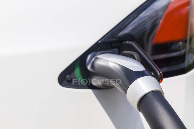 Carga de un coche eléctrico, primer plano - foto de stock