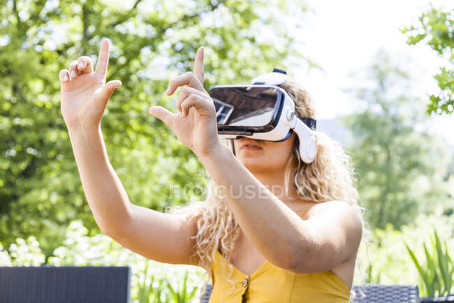 Young blond woman using virtual reality glasses outdoors — Stock Photo