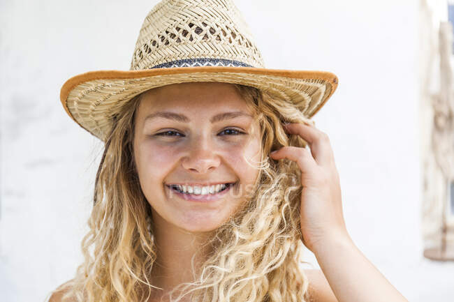 Retrato de una mujer rubia sonriente con sombrero de paja - foto de stock