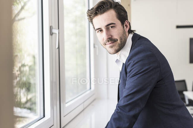 Uomo d'affari fiducioso in piedi alla finestra — Foto stock