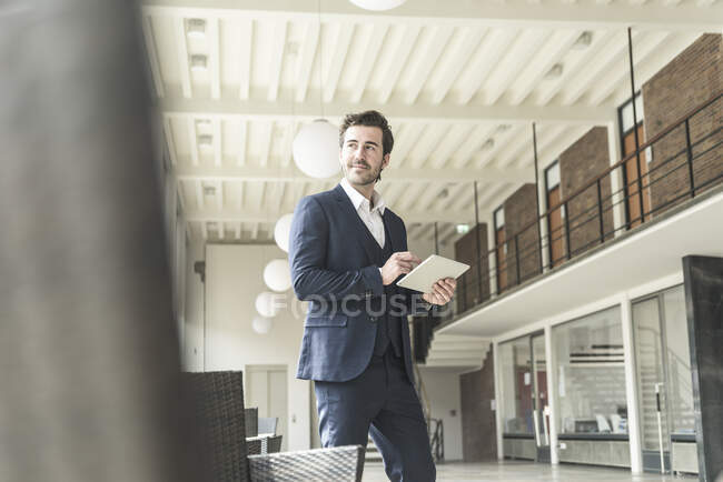 Manager di successo in piedi in un moderno edificio per uffici, utilizzando il computer portatile — Foto stock