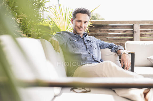 Hombre seguro relajándose en la terraza - foto de stock