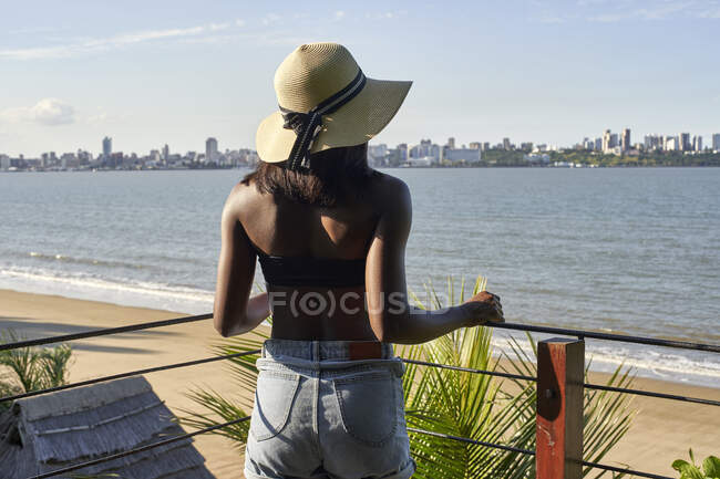 Молодая женщина на набережной смотрит на горизонт Мапуту, Мозамбик — стоковое фото