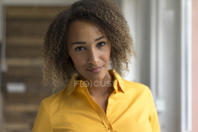 Porträt einer lächelnden jungen Frau im gelben Hemd — Stockfoto