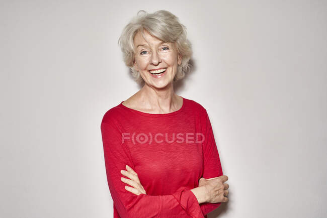 Retrato de mulher madura rindo vestindo pulôver vermelho — Fotografia de Stock