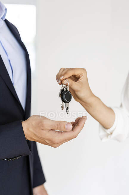 Businessman holding keys with a key — Stock Photo