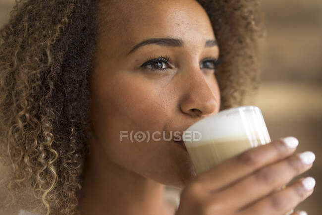 Young woman drinking Latte Macchiato — Stock Photo