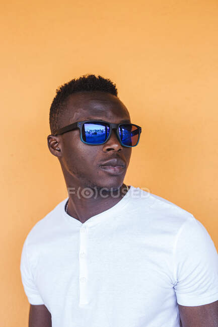 Портрет молодого человека в белой футболке и солнечных очках — стоковое фото