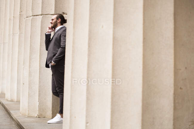 Young businessman on the phone standing among columns of Stock Exchange, New York City, USA — Stock Photo