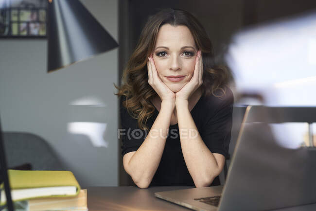 Ritratto di donna con computer portatile dietro il vetro della finestra — Foto stock