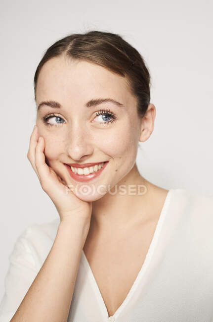 Porträt einer lächelnden jungen Frau mit dem Kopf in der Hand — Stockfoto