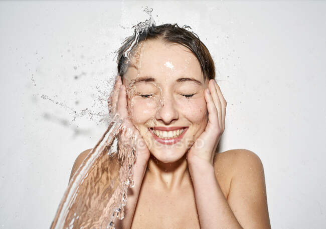 Портрет смеющейся молодой женщины с брызгами воды — стоковое фото