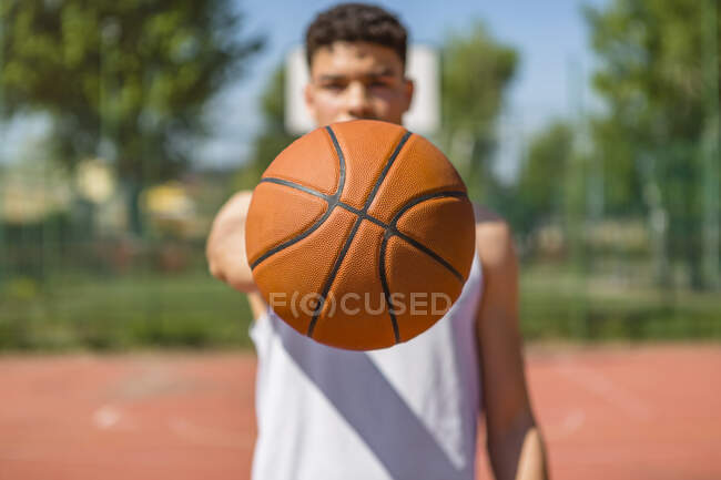 Jeune homme jouant au basket, donnant le basket — Photo de stock